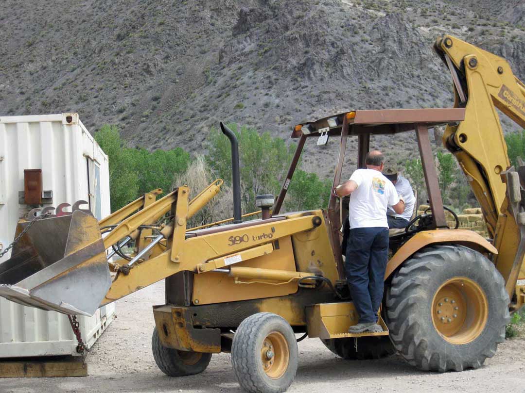 Dr. Bob supervises the onloading of a recycled portable office that will become a part of the eco-friendly farm.