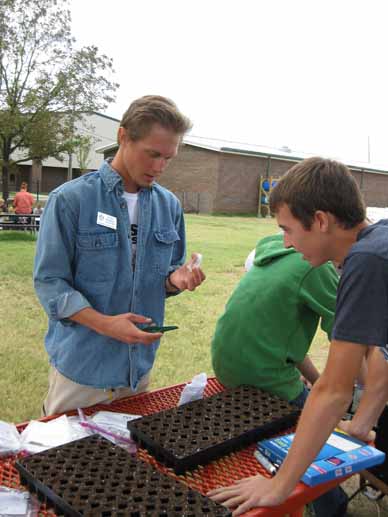 Ryan Norman of Delta Garden Study works with a high school student volunteer to prepare seeding trays.