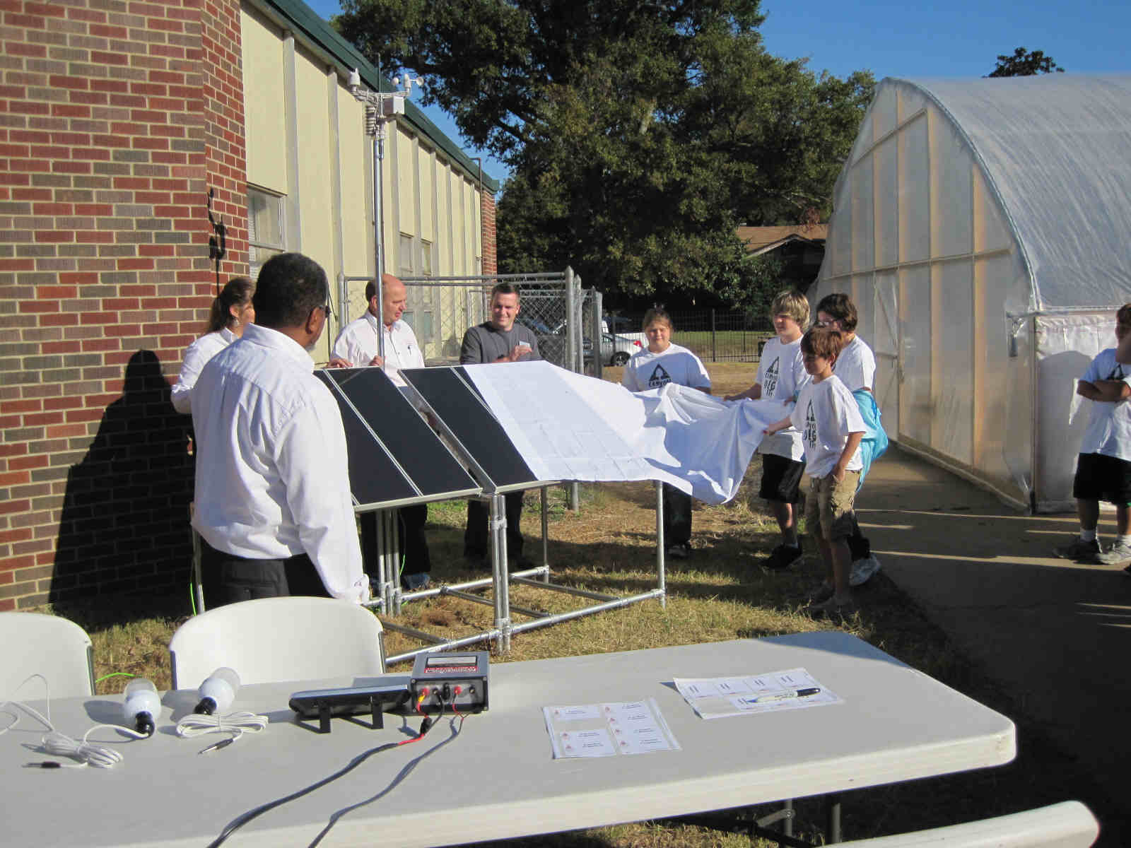 Students and faculity unveil their new solar array while members of MAREH assist.