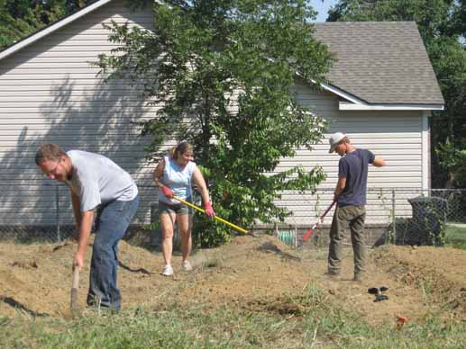 Nadine Straittof MAREH and Ryan Norman of the Delta Garden Study rake the raised beds flat while a volunteer shovels in forground.