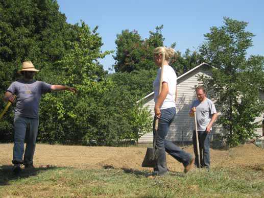 Jacob Holloway and Jill Zartman of FoodCorps measure out the raised beds.