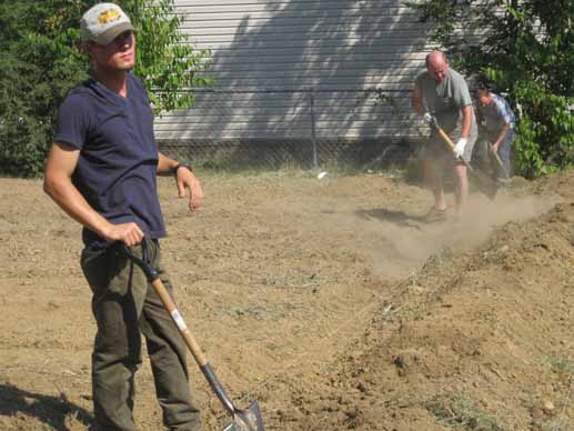 Ryan Norman of the Delta Garden Study reviews progress, while Dr. Bob shovels dirt for raised beds.